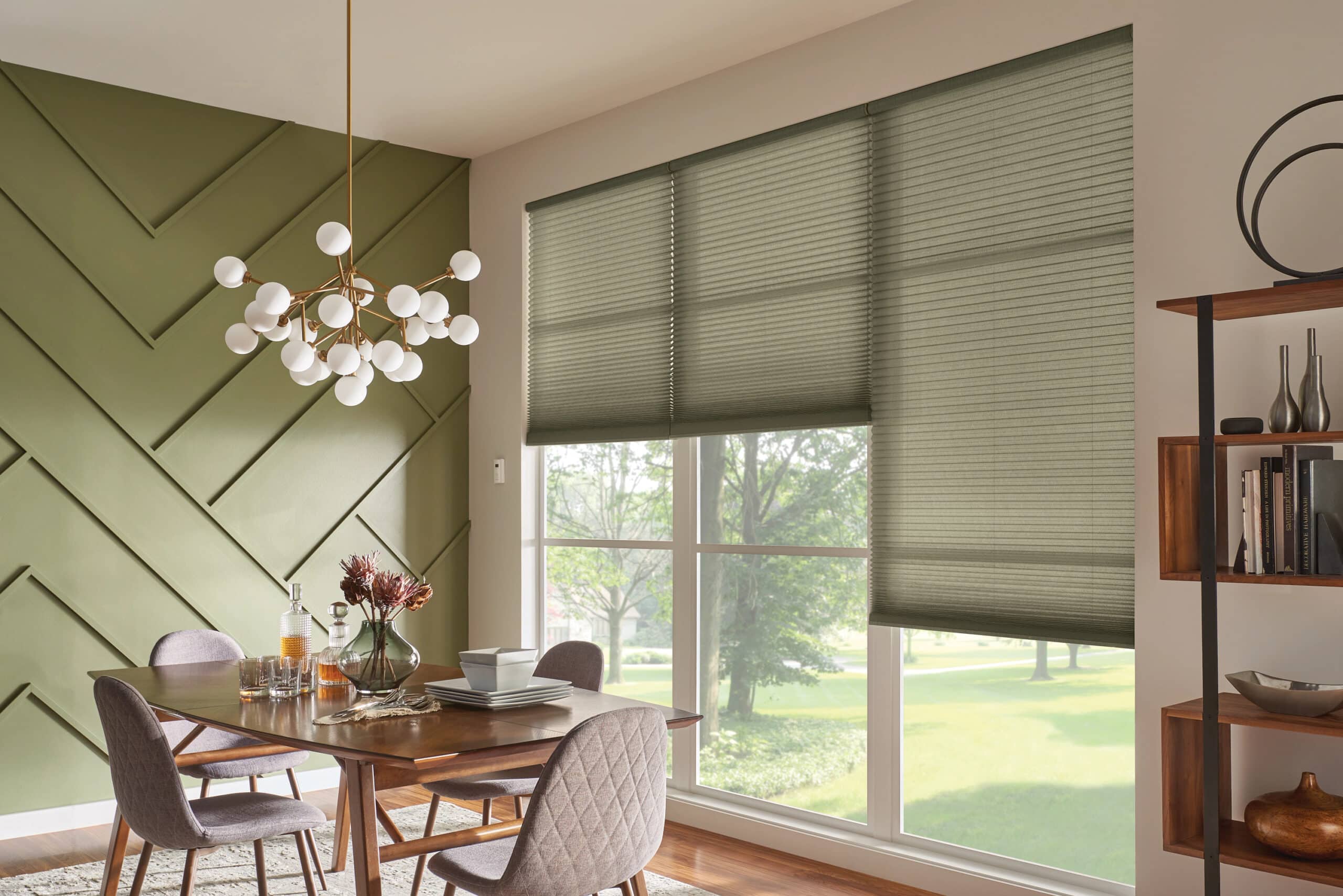Olive green cellular shades filtering in light to an olive green dining room. 